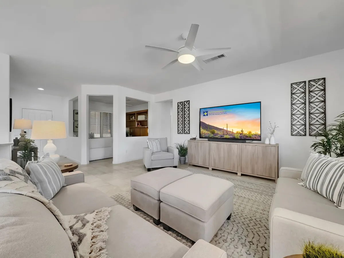 A cozy seating area with a large TV, decorative wall art, and a modern lamp, set against a backdrop of warm, inviting colors. The space feels comfortable and ideal for unwinding with family or hosting friends for a movie night.